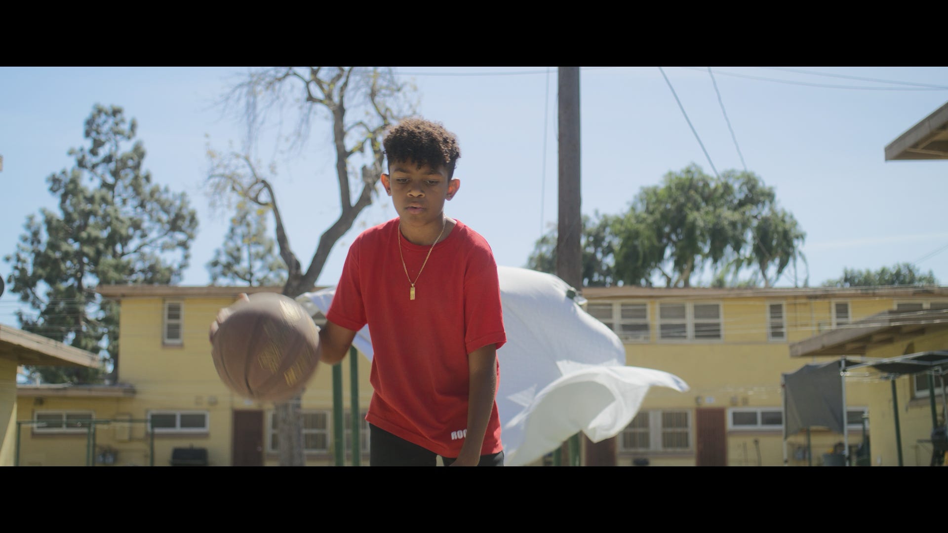 Film still — child with basketball, Nickerson Gardens
